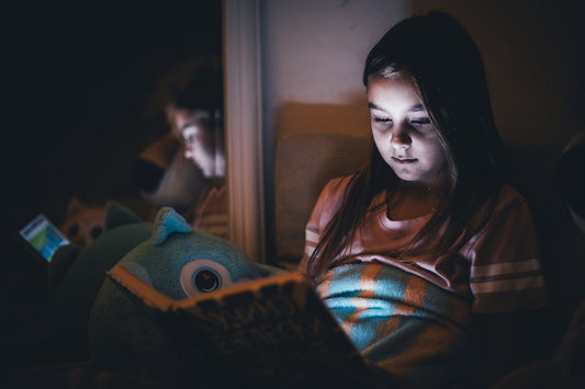 A child in a cozy, softly lit bedroom with a stuffed animal and a small wooden keepsake box on the nightstand, gifts for kids with nightmares