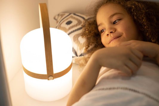 A child resting in a softly lit bedroom at night, illustrating the difference between night terrors and nightmares in children