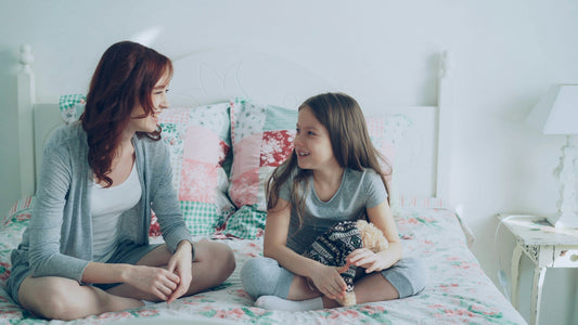 Parent listening to child talk about a bad dream at bedtime